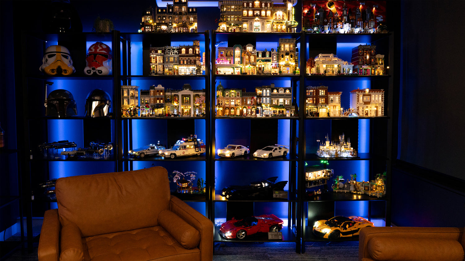 Shelving unit with model cars and buildings in a dimly lit room.